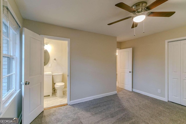 unfurnished bedroom featuring ceiling fan, connected bathroom, a closet, and carpet floors