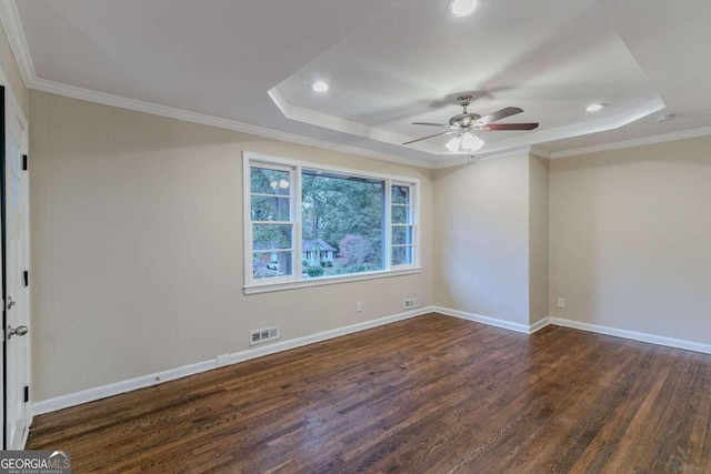 empty room with ornamental molding, ceiling fan, dark hardwood / wood-style floors, and a raised ceiling