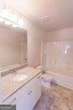 bathroom featuring vanity and  shower combination