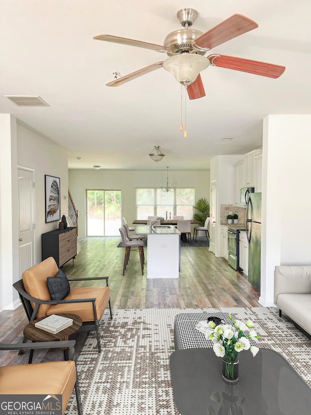 living room featuring hardwood / wood-style floors and ceiling fan