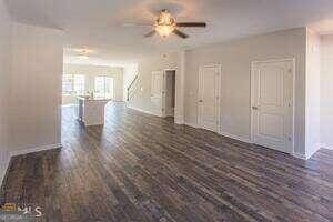 unfurnished room with ceiling fan and dark hardwood / wood-style flooring