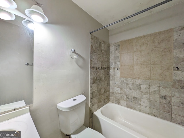 full bathroom featuring vanity, tiled shower / bath combo, and toilet