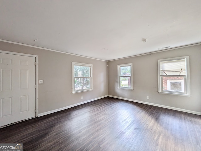 spare room with dark hardwood / wood-style floors and crown molding