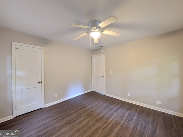 empty room with ceiling fan and dark wood-type flooring