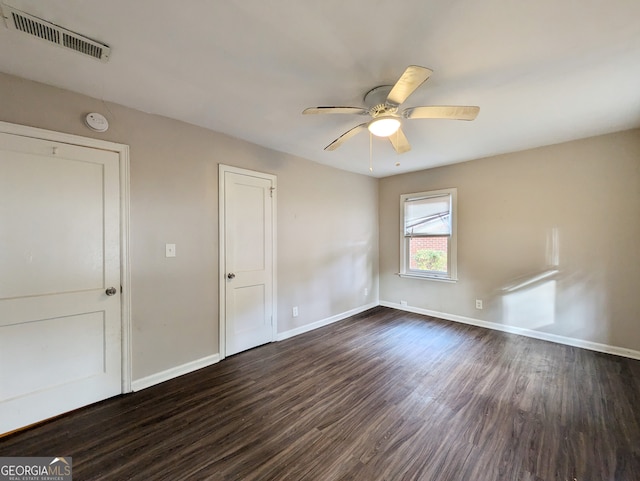 unfurnished bedroom with ceiling fan and dark wood-type flooring