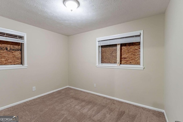 carpeted spare room featuring a textured ceiling