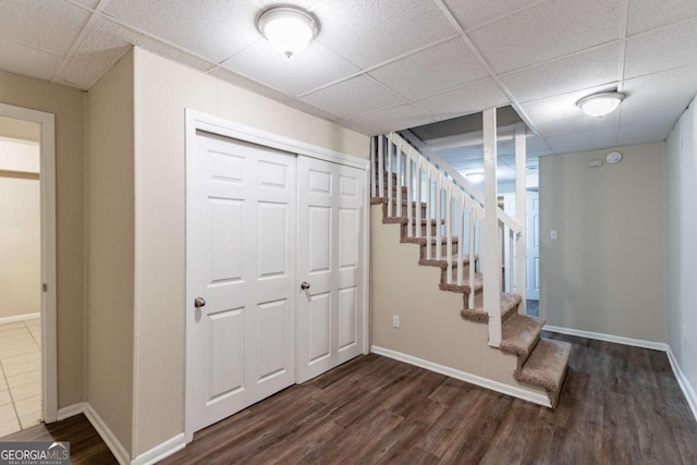 interior space with a drop ceiling and dark hardwood / wood-style flooring