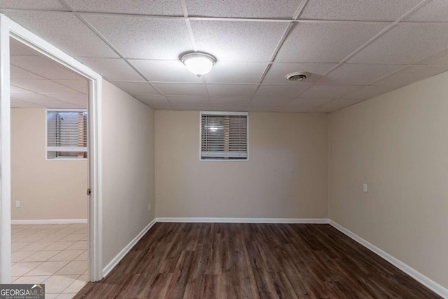 empty room featuring a drop ceiling and hardwood / wood-style flooring