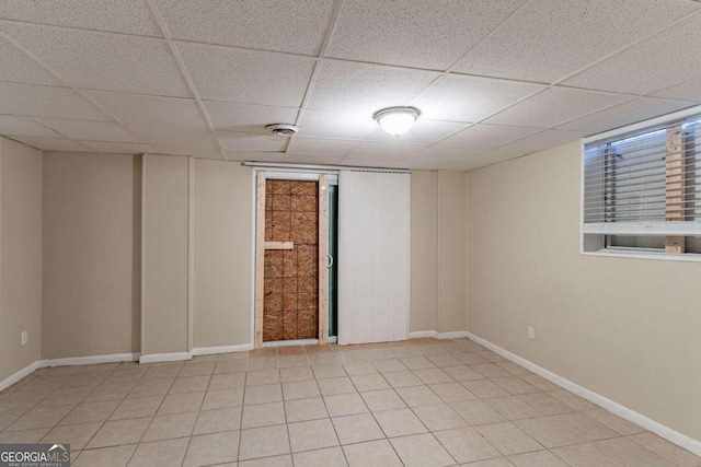 tiled spare room with a drop ceiling