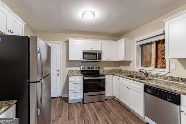 kitchen with dark hardwood / wood-style flooring, white cabinetry, sink, and stainless steel appliances