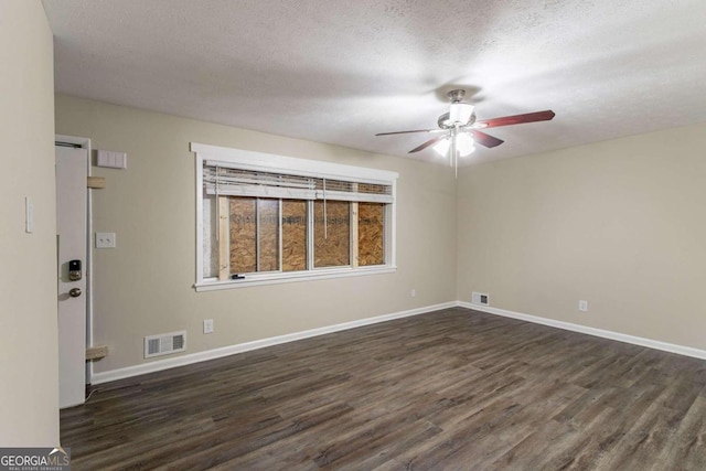 spare room with dark wood-type flooring, a textured ceiling, and ceiling fan