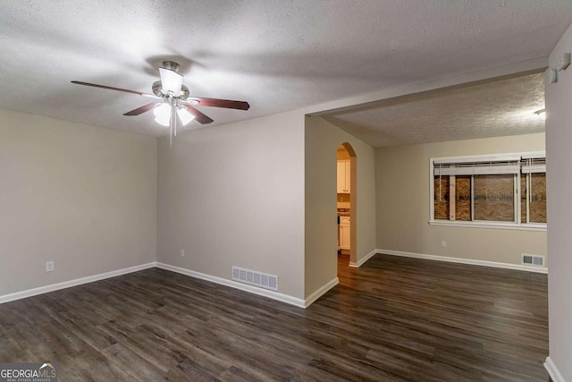 empty room featuring dark wood-type flooring, a textured ceiling, and ceiling fan