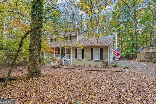 front of property featuring covered porch and a storage unit