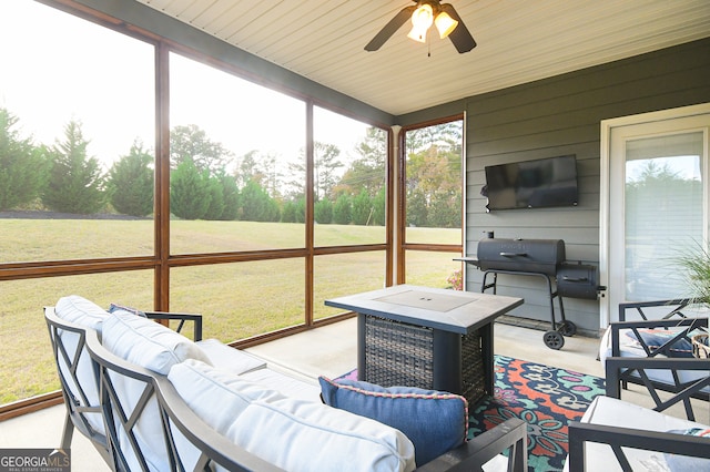 sunroom featuring ceiling fan and wood ceiling