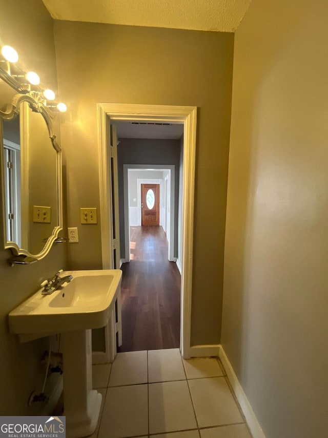 bathroom with wood-type flooring and a textured ceiling