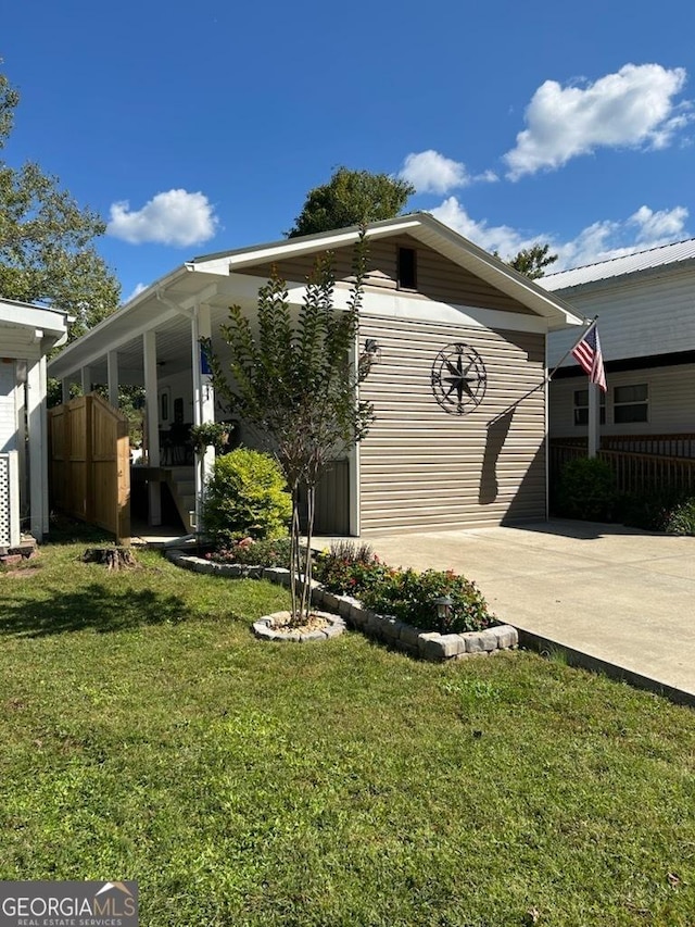 exterior space featuring a lawn, fence, and driveway