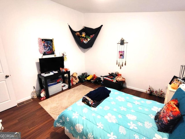 bedroom with dark hardwood / wood-style floors and vaulted ceiling