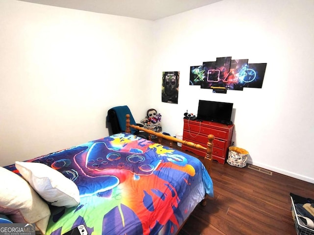 bedroom with dark hardwood / wood-style floors