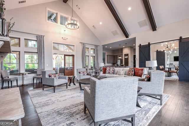 living area with beamed ceiling, a barn door, an inviting chandelier, dark wood-style flooring, and high vaulted ceiling