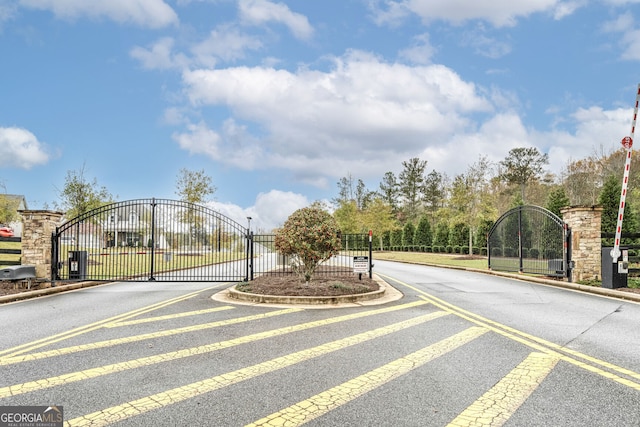 view of road featuring a gate, curbs, and a gated entry