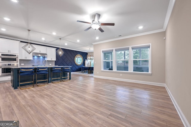 living room with ceiling fan, light wood-type flooring, and crown molding