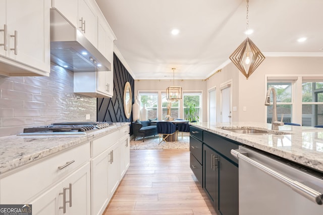 kitchen featuring white cabinetry, hanging light fixtures, appliances with stainless steel finishes, and plenty of natural light