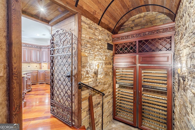 wine room featuring light hardwood / wood-style flooring, wooden ceiling, and beam ceiling