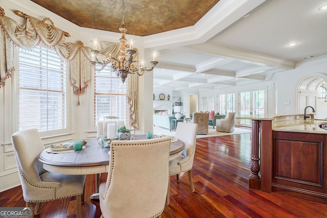 dining space with coffered ceiling, plenty of natural light, dark hardwood / wood-style flooring, and a notable chandelier