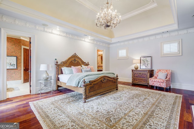 bedroom with ensuite bathroom, dark wood-type flooring, crown molding, and an inviting chandelier