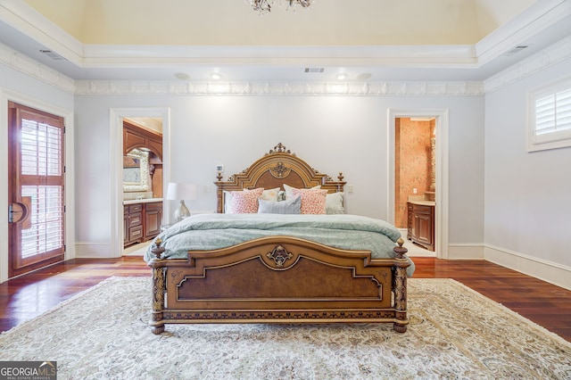 bedroom featuring hardwood / wood-style flooring, a high ceiling, ensuite bath, and crown molding