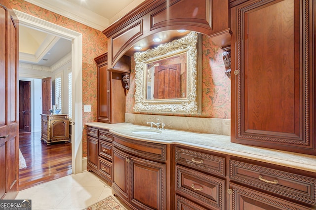 bathroom with ornamental molding, hardwood / wood-style floors, and vanity