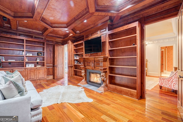 office space featuring light hardwood / wood-style floors, built in shelves, wood walls, coffered ceiling, and crown molding