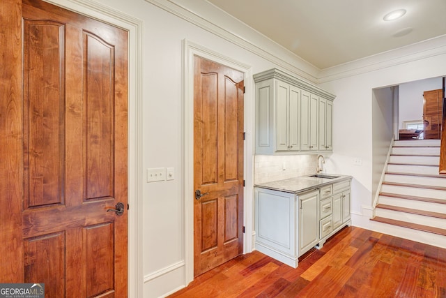 kitchen with decorative backsplash, light hardwood / wood-style floors, sink, and crown molding