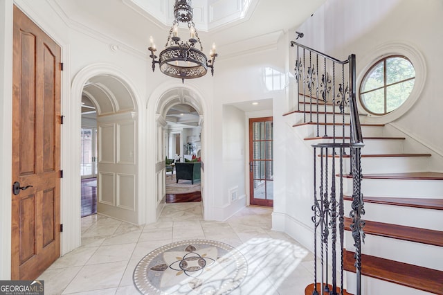 foyer featuring a notable chandelier and crown molding