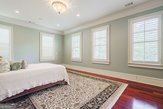 bedroom with multiple windows, dark hardwood / wood-style flooring, and ornamental molding