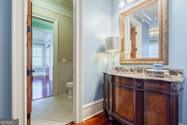 bathroom with toilet, vanity, tile patterned floors, and ornamental molding