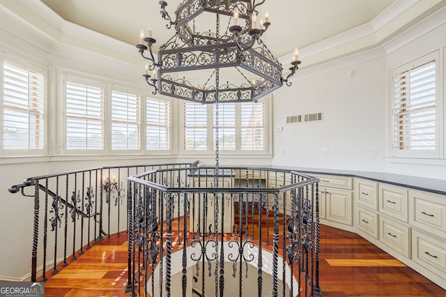 interior space with a chandelier, wood-type flooring, and a healthy amount of sunlight