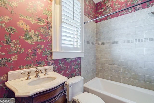 full bathroom with toilet, vanity, and tiled shower / bath