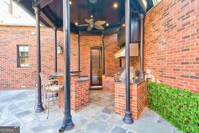 view of patio featuring grilling area, ceiling fan, a bar, and exterior kitchen