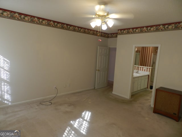 unfurnished bedroom featuring ceiling fan, ensuite bathroom, and light colored carpet