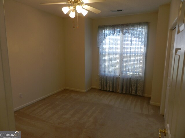 empty room with light colored carpet and ceiling fan