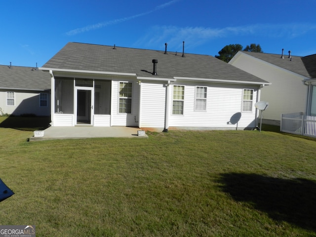 back of property with a lawn, a sunroom, and a patio