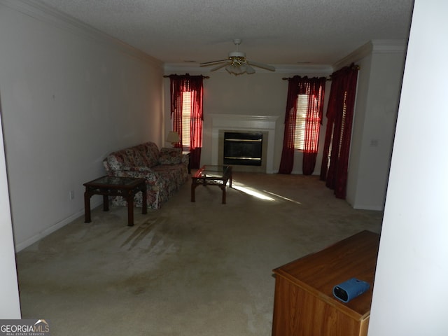 carpeted living room featuring ceiling fan, a textured ceiling, a healthy amount of sunlight, and crown molding