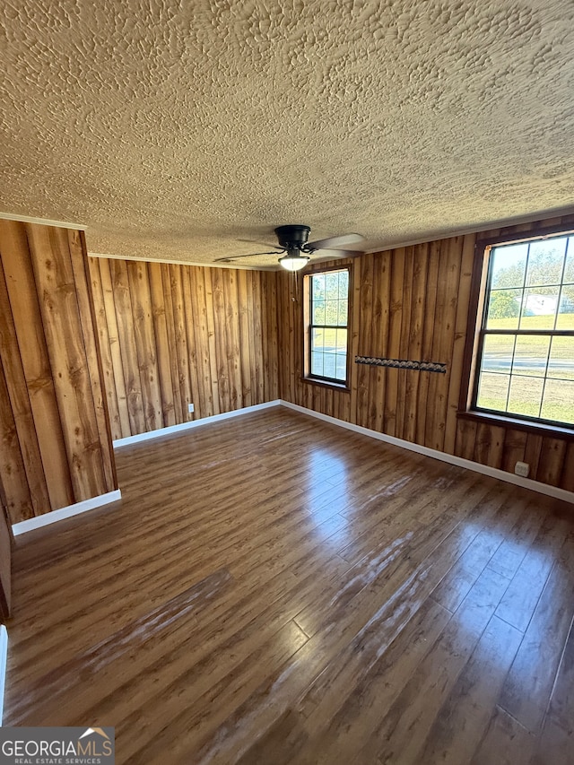 unfurnished room featuring dark hardwood / wood-style floors and wood walls