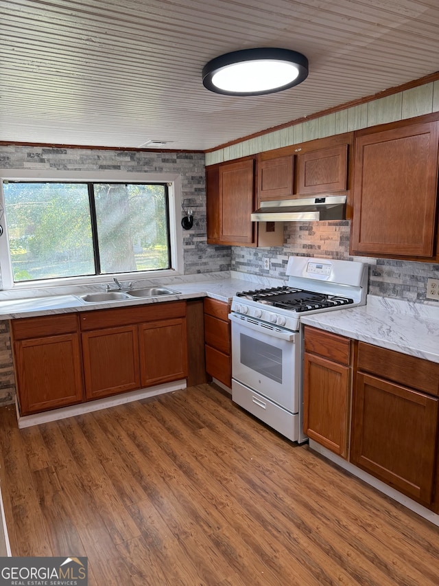 kitchen featuring hardwood / wood-style floors, crown molding, white range with gas stovetop, and sink