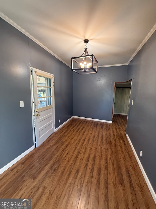 unfurnished dining area with crown molding, dark wood-type flooring, and a notable chandelier