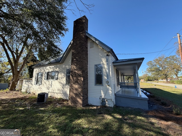 view of home's exterior with a lawn and central air condition unit