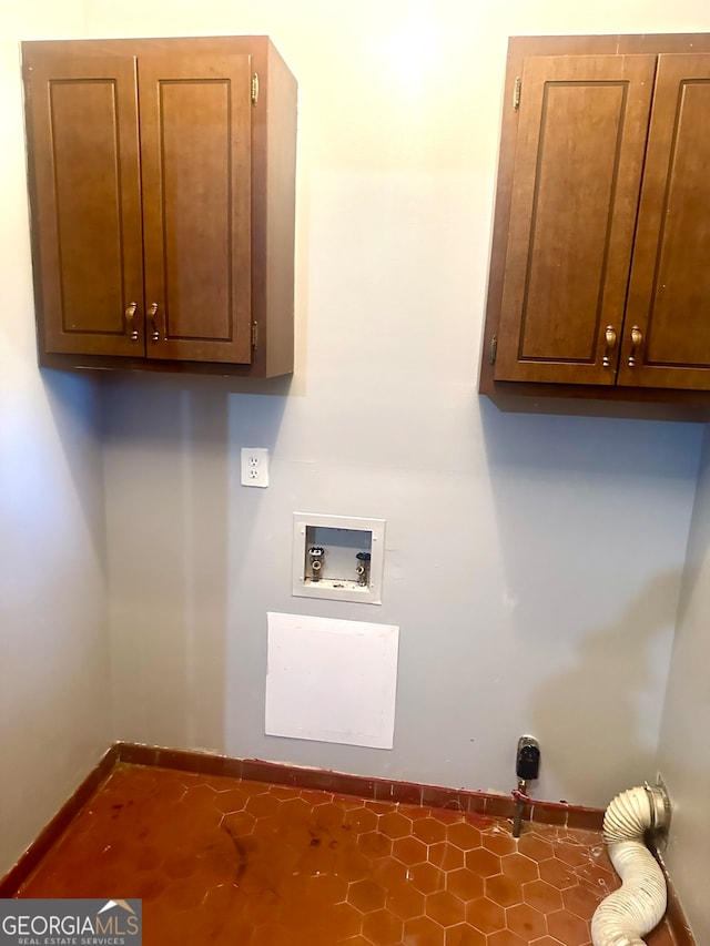 washroom featuring dark tile patterned floors, washer hookup, cabinets, and hookup for an electric dryer