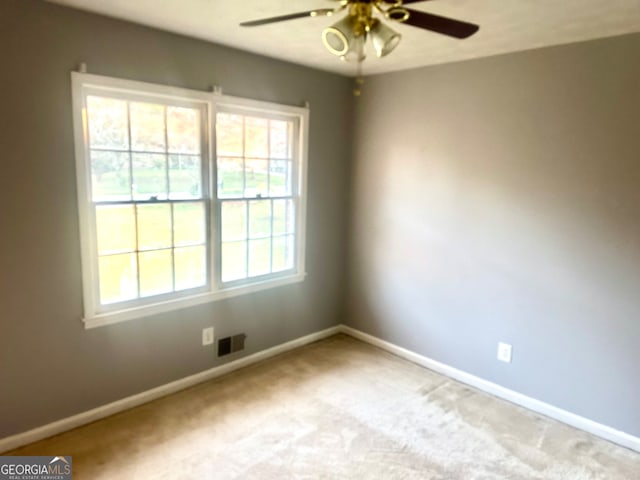 spare room with light carpet and ceiling fan