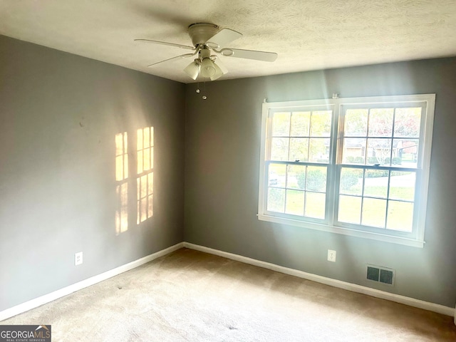 carpeted spare room with a wealth of natural light and ceiling fan